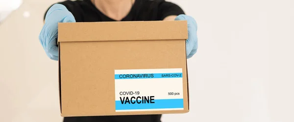 lab assistant carrying box with vaccines for Covid 19.