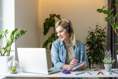 Çekici pozitifin fotoğrafı. Masaüstüne otur. Bilgisayarı kullan..