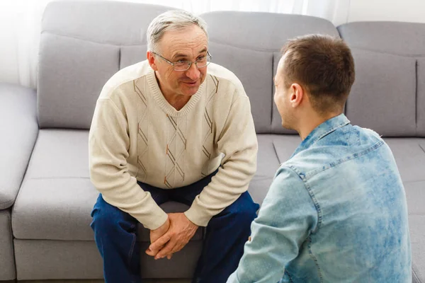 Vuxen Son Sitta Soffan Koppla Med Senior Pappa Prata Dela — Stockfoto