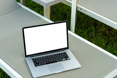 havuzun yanında boş ekran olan dizüstü bilgisayar.