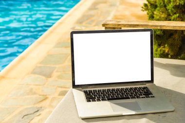 havuzun yanında boş ekran olan dizüstü bilgisayar.