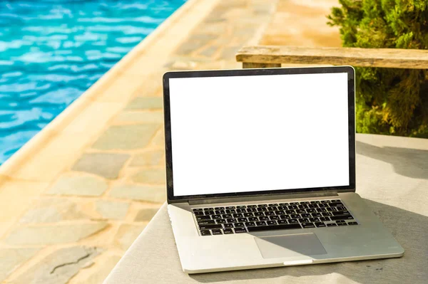 havuzun yanında boş ekran olan dizüstü bilgisayar.