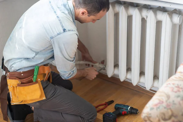 Repair heating radiator close-up. man repairing radiator.
