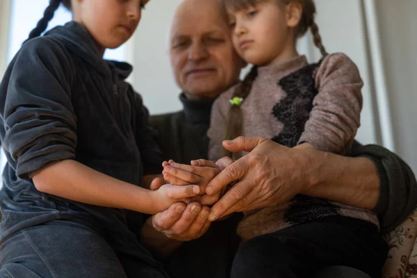 Hands of the old man and a childs hand