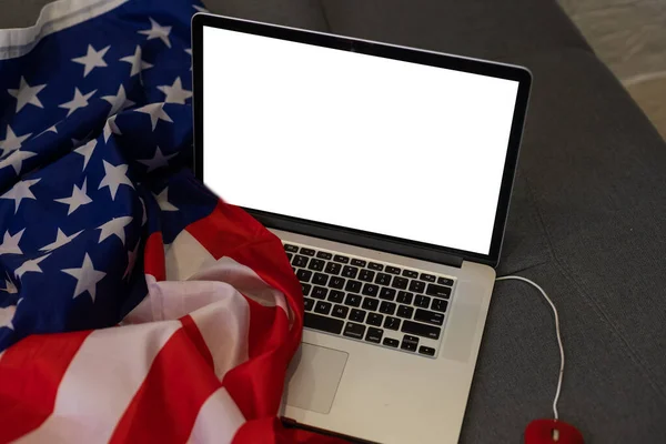 Laptop with blank screen and USA flag.