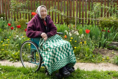 Tekerlekli sandalyedeki yaşlı kadın..
