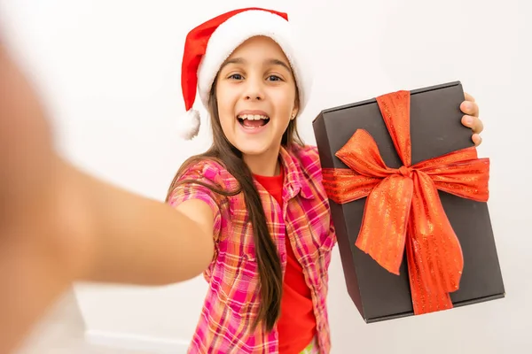 Sorrindo Criança Engraçada Chapéu Vermelho Santa Segurando Presente Natal Mão — Fotografia de Stock