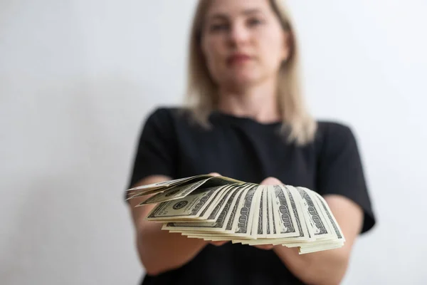 woman holding money over white wall background.