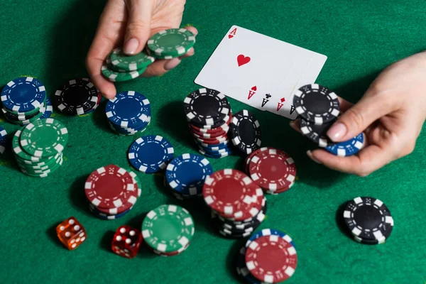 A woman plays in a casino. opening cards to raise bets. Against the background of chips. Poker victory.