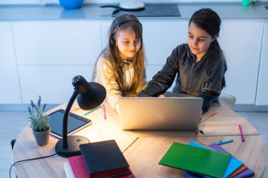 Bağlantı iyi. Seni duyabiliyorum. Küçük kız rahat masa başı çalışma uzaktan bilgisayarla internet üzerinden öğretmenlerle iletişim kurma ev içinde kulaklık var.