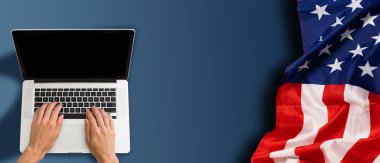 Boş ekranlı dizüstü bilgisayar ve masada ABD bayrağı. Yüksek kalite fotoğraf