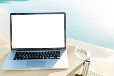 Yüzme havuzunun yanında boş ekranlı bilgisayar bilgisayarı.