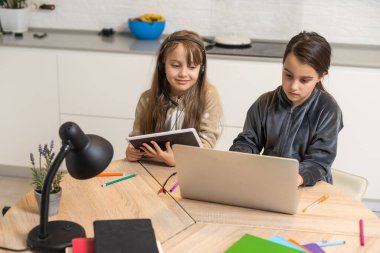 Bağlantı iyi. Seni duyabiliyorum. Küçük kız rahat masa başı çalışma uzaktan bilgisayarla internet üzerinden öğretmenlerle iletişim kurma ev içinde kulaklık var.