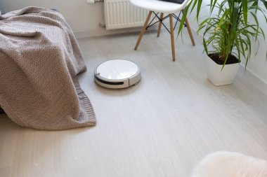 Robot elektrikli süpürge yatak odasında lamine ahşap zemin üzerinde