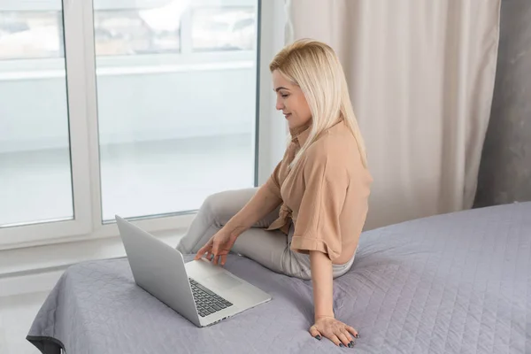 Woman in a cozy interior using a laptop. Womens hobby, searching for references and materials, learning.