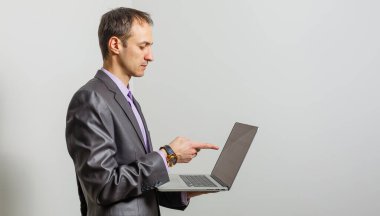 Gri arka planda duran havalı iş adamı