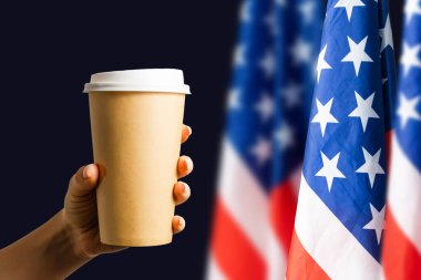Closeup of American flag with coffee paper cup