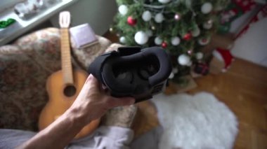 3d glasses watching virtual reality in headwear near xmas tree.