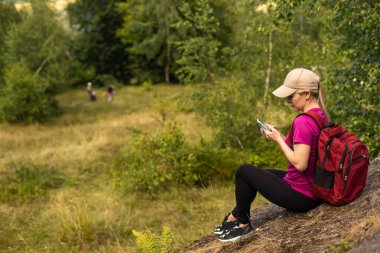 Genç bayan yürüyüşçü akıllı telefon dağı kullanıyor.