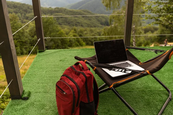 Computer on the lounger mountain trees front view background