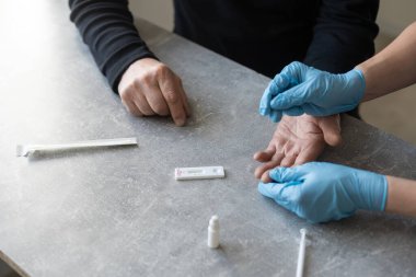 Hemşire evinde yaşlı bir adama koronavirüs pCR testi yapıyor..
