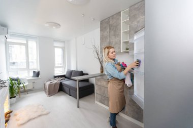 Genç gülümseyen profesyonel temizlik servisi buzdolabı mutfak temizlik kadın.