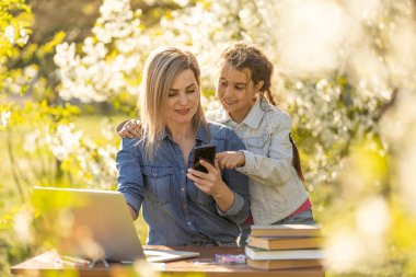 Neşeli küçük liseli kız evde bilgisayarla çalışırken öğretmeniyle konuşuyor ve ona destek oluyor..