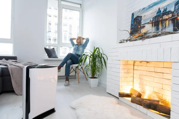 Woman In Living Room Using Air Cleaner And Humidifier.