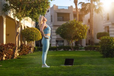 Geri çekilmek ve tatil. Otel bahçesinde egzersiz yapan bir kadın..