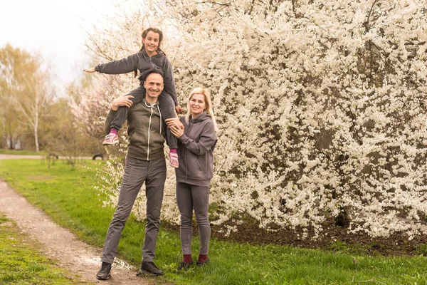 Çiçekli Bahçede Ağaçlı Bir Aile — Stok fotoğraf