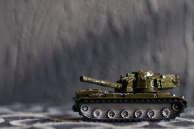 Koyu arkaplanda Yeşil Plastik Tank Oyuncağı.