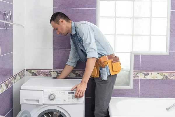 Homem Trabalhador Encanador Repara Uma Máquina Lavar Roupa Lavanderia — Fotografia de Stock