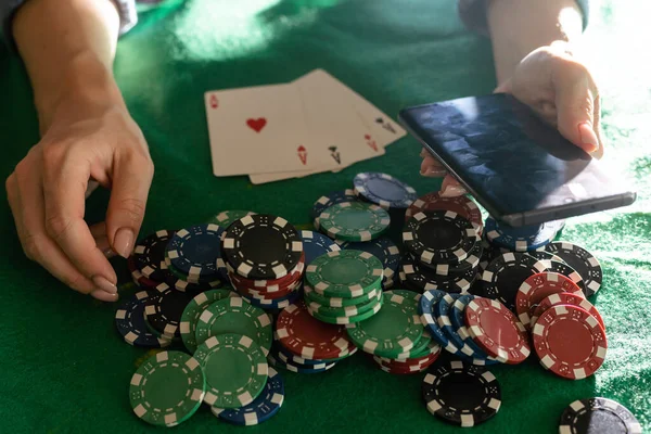 A woman plays in a casino. opening cards to raise bets. Against the background of chips. Poker victory.