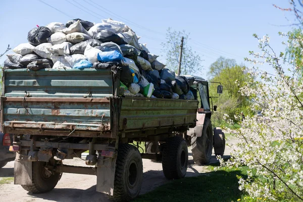 Bags with garbage in the trailer, cleaning the territory.