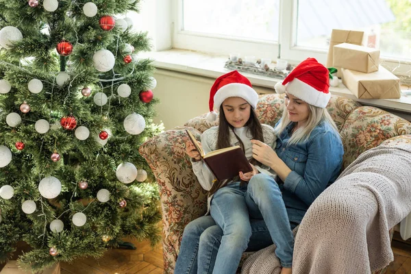 Pretty Young Mother Reading Book Her Daughter Christmas Tree — ストック写真