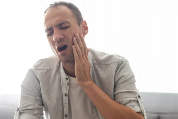 Mandlig Patient Med Svær Tandpine Rørende Kind Med Grimace Smerte - Stock-foto