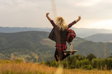 Çayır üzerinde yürüyen sırt çantası olan güzel kadın. Uzun yürüyüşe çıkan kimse kız açık portresi.