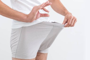 İç çamaşırlı bir adam hap tutuyor..