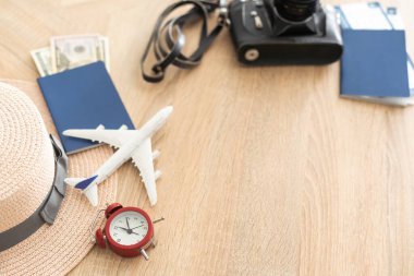 Preparation for Traveling concept, watch, tickets, money, passport, airplane on a vintage wooden background with copy space