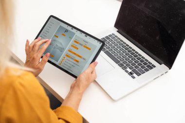 Zaman çizelgemi kontrol edelim. Neşeli, genç ve güzel bir kadın iş yerinde otururken gülümseyerek dokunmatik dokunmatik yastığını kullanıyor..