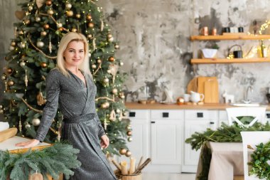 parti, içkiler, tatiller, insanlar ve kutlama konsepti - gece elbisesi içinde gülümseyen kadın Noel ağacı ışıkları arka planında.