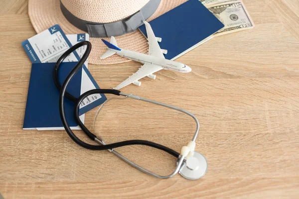 Medical Tourism, medical travel concept. Stethoscope, toy plane and passport on wooden background.