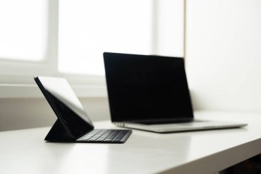 Bilgisayar ve tablet beyaz bir masada.