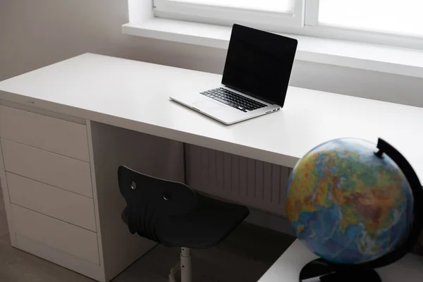 modern workspace with blank screen laptop on white table with white wall background.