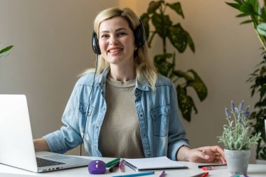 Pretty female student with cute smile keyboarding something on net-book while relaxing after lectures in University, beautiful happy woman working on laptop computer.