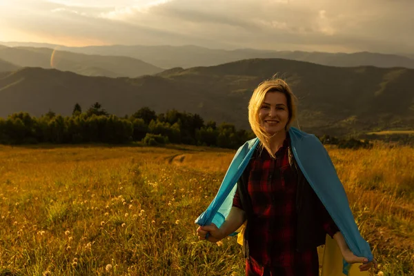 Açık havada Ukrayna 'nın sarı ve mavi bayrağını tutan bir kadın. Bağımsızlık Günü. Bayrak Günü. Anayasa günü. Geleneksel Ukrayna bayrağı nakışlı kadın.