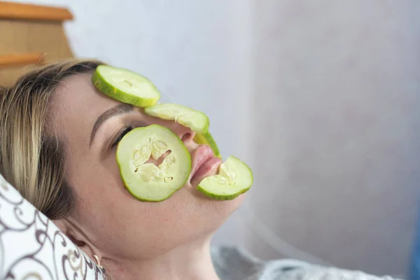 Young beautiful woman with Face pack and fresh cucumber slices on her eyes. Homemade Mud Facial Mask at Home. Multani soil face-pack, gold facial. Beauty, skin care, spa.