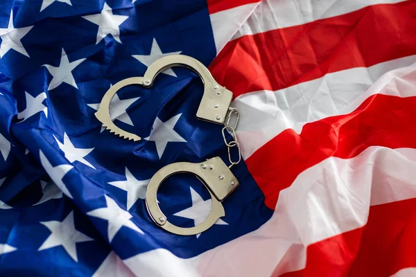 Police handcuffs on the USA flag, close-up,