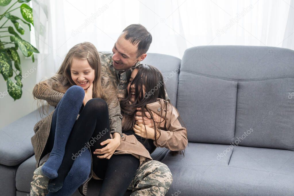 beautiful little daughters and military father at home.