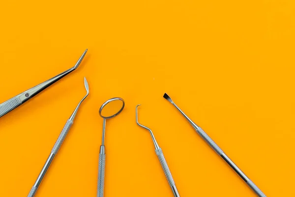 Professional Dentist tools in dental office: dentist mirror, forceps curved, explorer curved, dental explorer angular and explorer curved with chip, right. Dental Hygiene and Health.